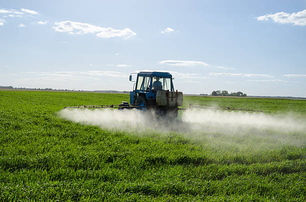 tracteur spray de l'engrais field pesticide chimique - spraying agriculture farm herbicide photos et images de collection