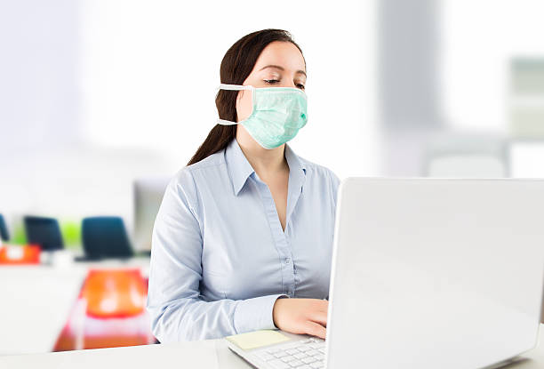 istock Masked woman in the office 495627378