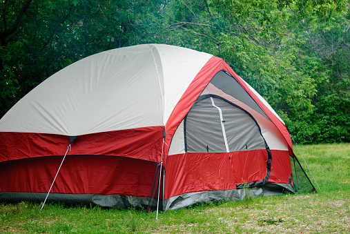 red and grey tent with all logos removed and is at a campsite in Lundar Manitoba