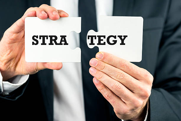 istock Man holding two pieces of a puzzle with Strategy 495627905