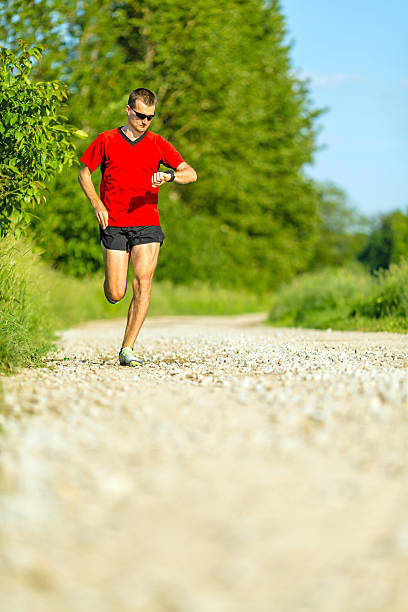 istock Man trail running on country road 495629369