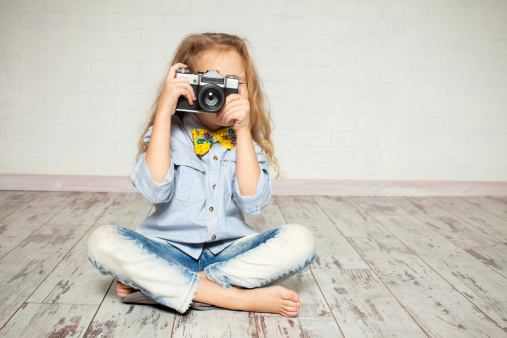 Child with camera. Little girl photographing