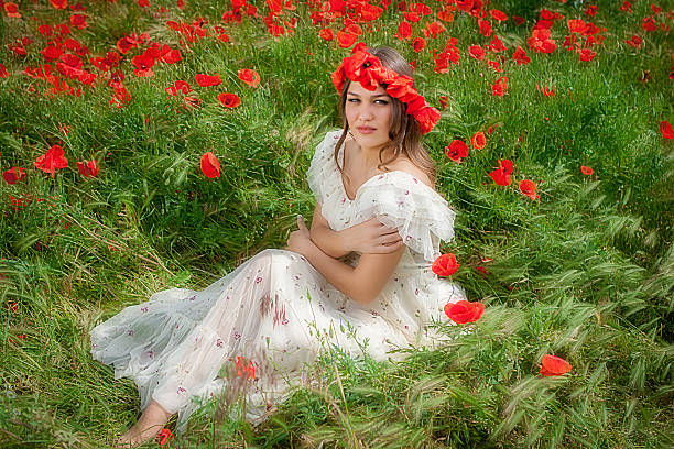 Bella donna seduta nel fiore di papavero - foto stock
