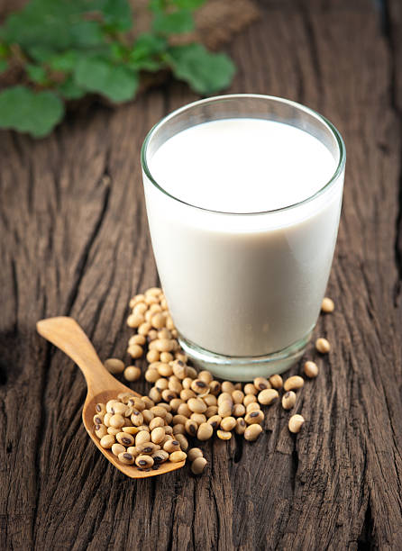 leche de soja con granos en madera - soymilk fotografías e imágenes de stock