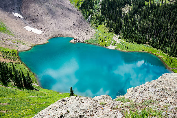 Blue Lakes Mt. Sneffels Wilderness Area The first of 3 glacial lakes found on the Blue Lakes trail just outside of Ridgway Colorado. This first lake is a crystal glacial lake of the most beautiful blue that can only truly be appreciated by climbing the trail above it to get a full view. Surrounded by mountain views, meadows, flowing creeks. The area is known for the wildflowers and mushrooms found all over in a rare display.  ridgway stock pictures, royalty-free photos & images