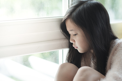 Portrait of asian beautiful sad girl at the window,vintage filter
