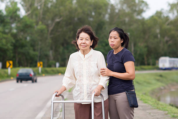 istock senior woman using a walker cross street 495641272