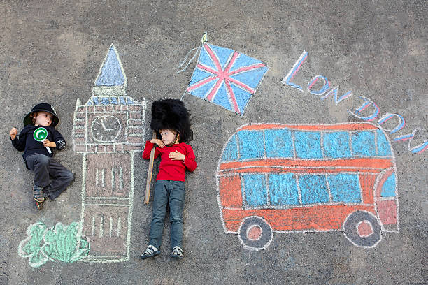 istock Two little kids with London picture drawing with chalks 495644858