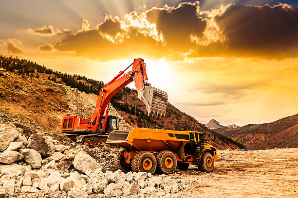 istock Excavator loading dumper truck at sunset 495645766