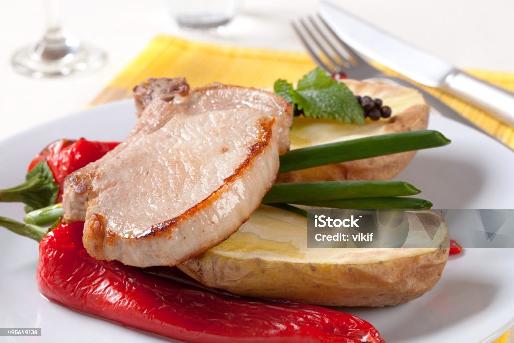 Roasted pork chop with  potato and red peppers Roasted pork chop served with potato and red peppers 2015 Stock Photo