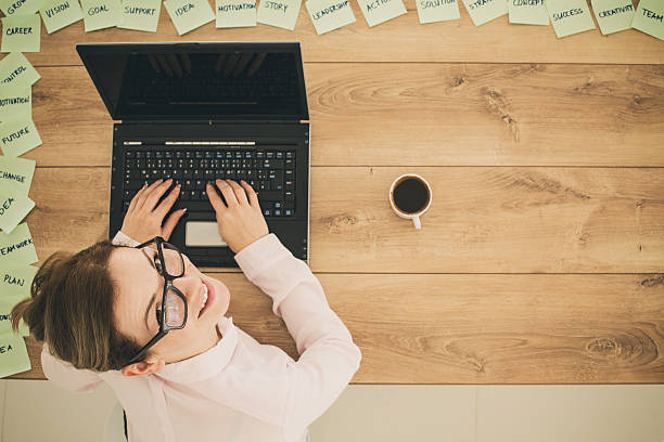 istock Woman working on laptop, looking at camera 495649242
