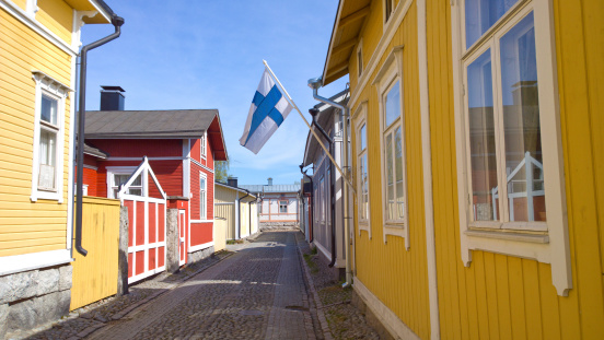 Beautiful Old Rauma UNESCO World Heritage Site on a sunny summer day. Finnish flag in the middle.