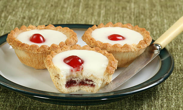 cherry bakewells on a plate cherry bakewll pies on a green and white plate bakewell stock pictures, royalty-free photos & images