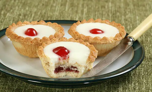 cherry bakewll pies on a green and white plate