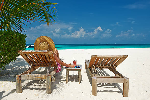 istock Woman at beach with chaise-lounges 495652891