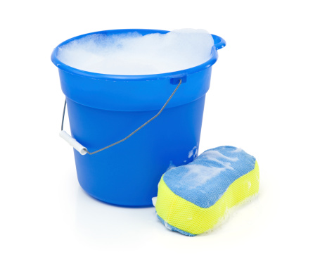 Blue bucket with soapy water and a sponge. Isolated on white.