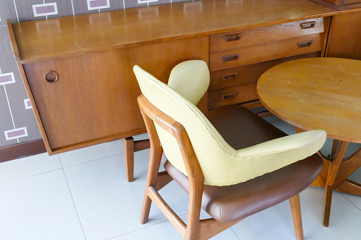 brown leather cushion  on wooden chair, wooden desk and cabinet