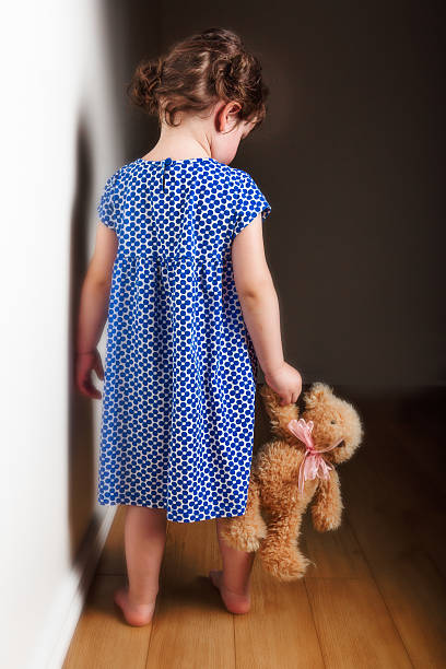 Backview little girl holding teddy bear Portrait of a cute little girl with her teddy bear nervous holding hands stock pictures, royalty-free photos & images