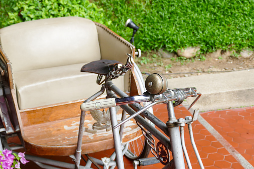 old classic traditional asian tricycle with beige leather cushion