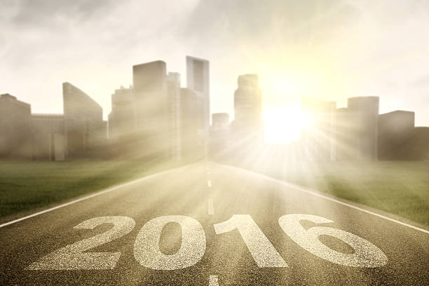 Image of empty highway with numbers 2016 and bright sunlight toward the city