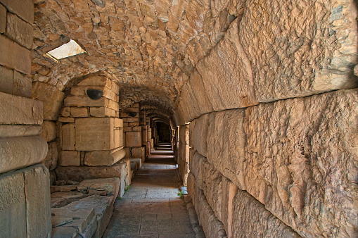 ruins of ancient greek tunnel made of stone with light shining through holes in Ephesus, Turkey