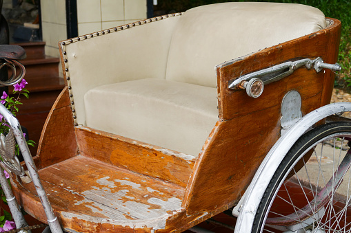 old classic traditional asian tricycle with beige leather cushion