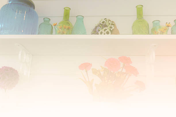istock blue and green bottle, flower in vase decorating on shelf 495663770