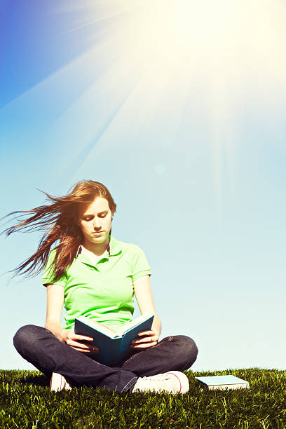 istock Cute student happily studying outdoors on sunny, breezy day 495666156