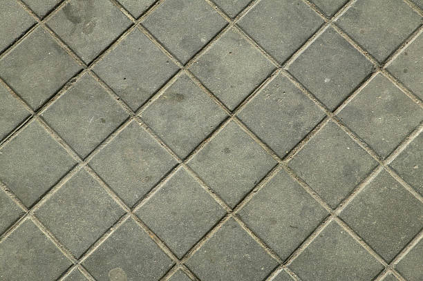 istock Dirty grey sidewalk with square parts 495667593