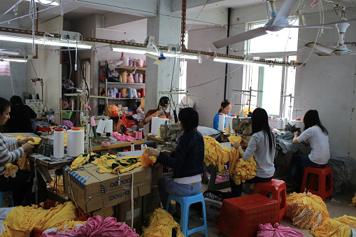 Puning, Сhina - March 18, 2013: the unidentified labors work in family business clothing workshop in Puning,Canton or Guangdong . China Manufacturing trend to move from coastal to inland area because the cost is growth