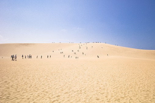 Tottori, Japan - August 8, 2015: The Tottori Sand Dunes (Tottori Sakyu) are the largest sand dunes in Japan and Tottori's most famous tourist attraction. Located just outside the city center, they span roughly 16 kilometers of coast along of the Sea of Japan and are up to two kilometers wide and 50 meters high. They are part of the Sanin Kaigan National Park.