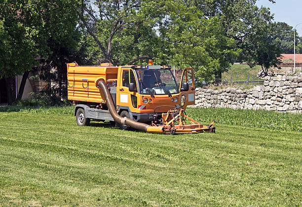 istock Lawn mower yellow truck cutting grass 495671115