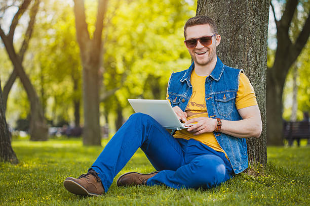 istock young man in the park with laptop 495671553