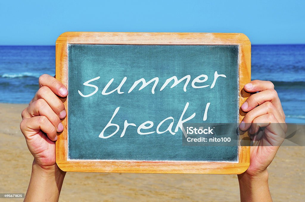 summer break man hands holding a chalkboard on the beach with the text summer break written in it Beach Stock Photo
