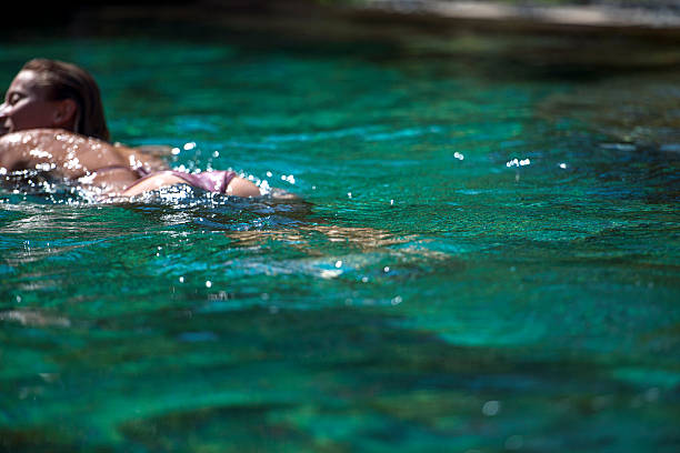 istock Young woman swimming in water 495672133