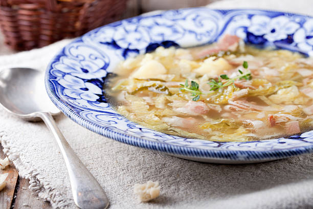 istock Cabbage soup with bacon, potato, meat, ceramic plate, bread 495672412