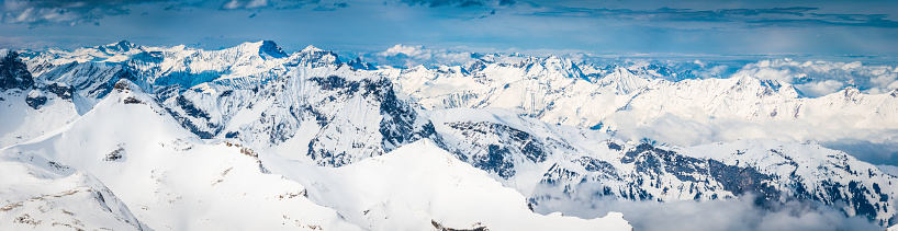 High altitude panoramic view across the crisp white glaciers, snow capped summits and dramatic rocky ridges of the Alps high in the idyllic mountain wilderness of the Bernese Oberland and Valais, Switzerland. ProPhoto RGB profile for maximum color fidelity and gamut.