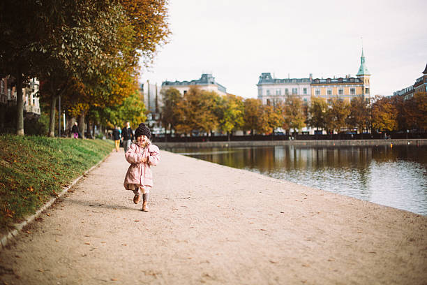 Toddler girl running by the lakes in Copenhagen stock photo