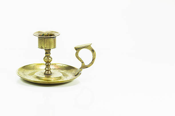 A vintage brass candle holder that can be held in your hand.