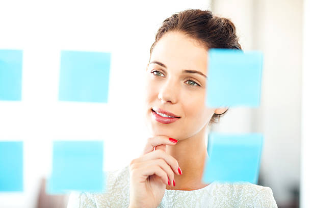 istock Businesswoman Analyzing Adhesive Notes Stuck On Glass Wall 495685339