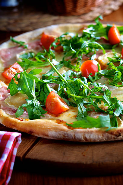 istock Pizza with rocket salad, ham and cherry tomatoes 495685389