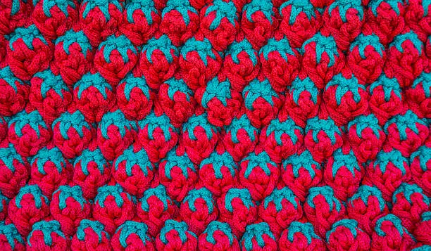 Close-up picture of knittingwool with red and green strawberry pattern. 
