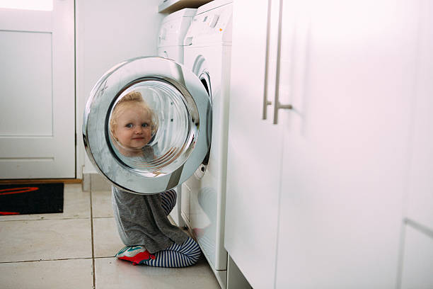 Toddler helping with the laundry stock photo