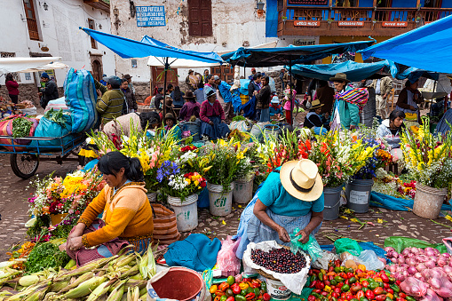 Pisac, Peru - December 22, 2013: People in a street market in the city of Pisac in Peru. The street market in Pisac is one of the largest in the Sacred Valley area.