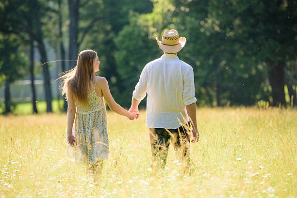 istock Young couple walking on meadow 495690686