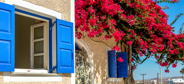 A house in Emborio with colorful Bougainvillea and a blue door in Santorini.