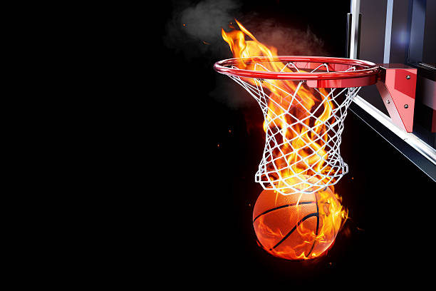 Flaming basketball going through a court net. stock photo