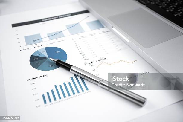 Businessman Analyzing Investment Charts With Laptop Stock Photo - Download Image Now