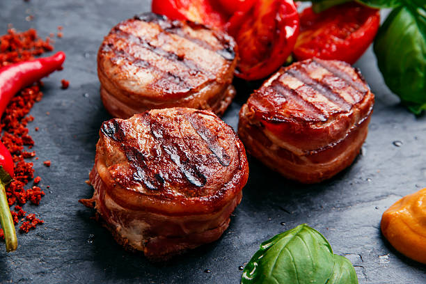 Grilled meat fillet steak wrapped in bacon medallions Grilled meat fillet steak wrapped in bacon medallions bacon wrapped stock pictures, royalty-free photos & images