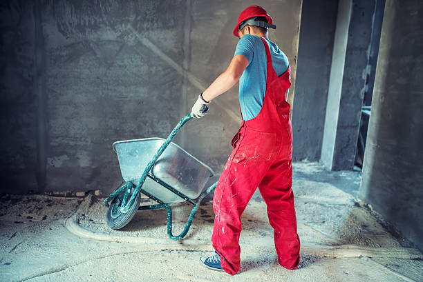 istock industrial worker, engineer on construction site, pushing a wheelbarrow 495696706